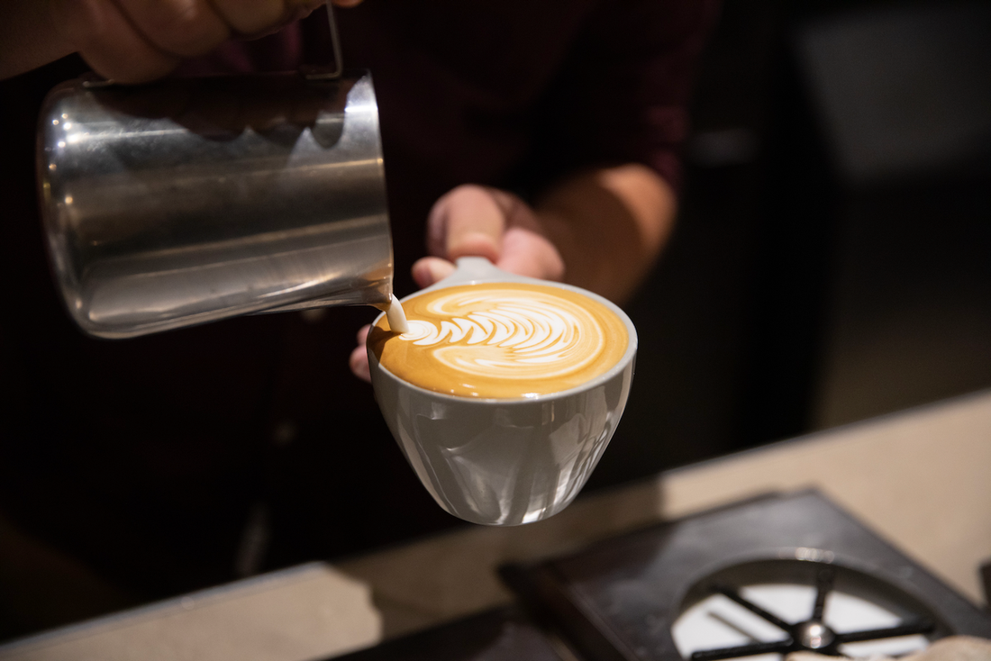 Barista pouring latte art at Indaba Coffee