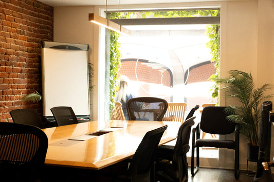 Indaba Riverside meeting room with exposed brick, conference table and leafy window